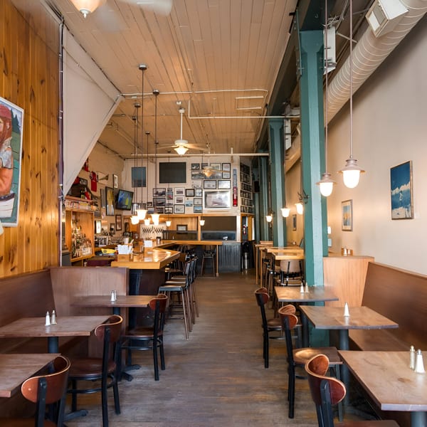 Interior of Andy's Old Port Pub, showing the bar area, dining tables, and wooden booths.